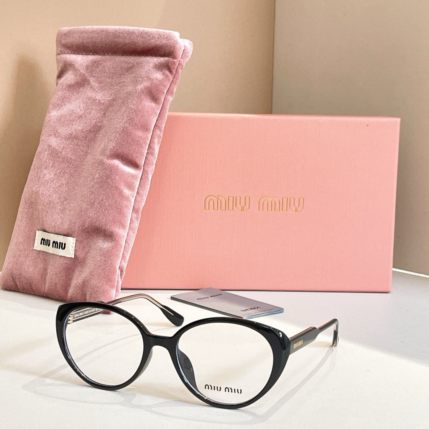 MiuMiu eyeglasses with black full-rim frames and “miu miu” logo on lens