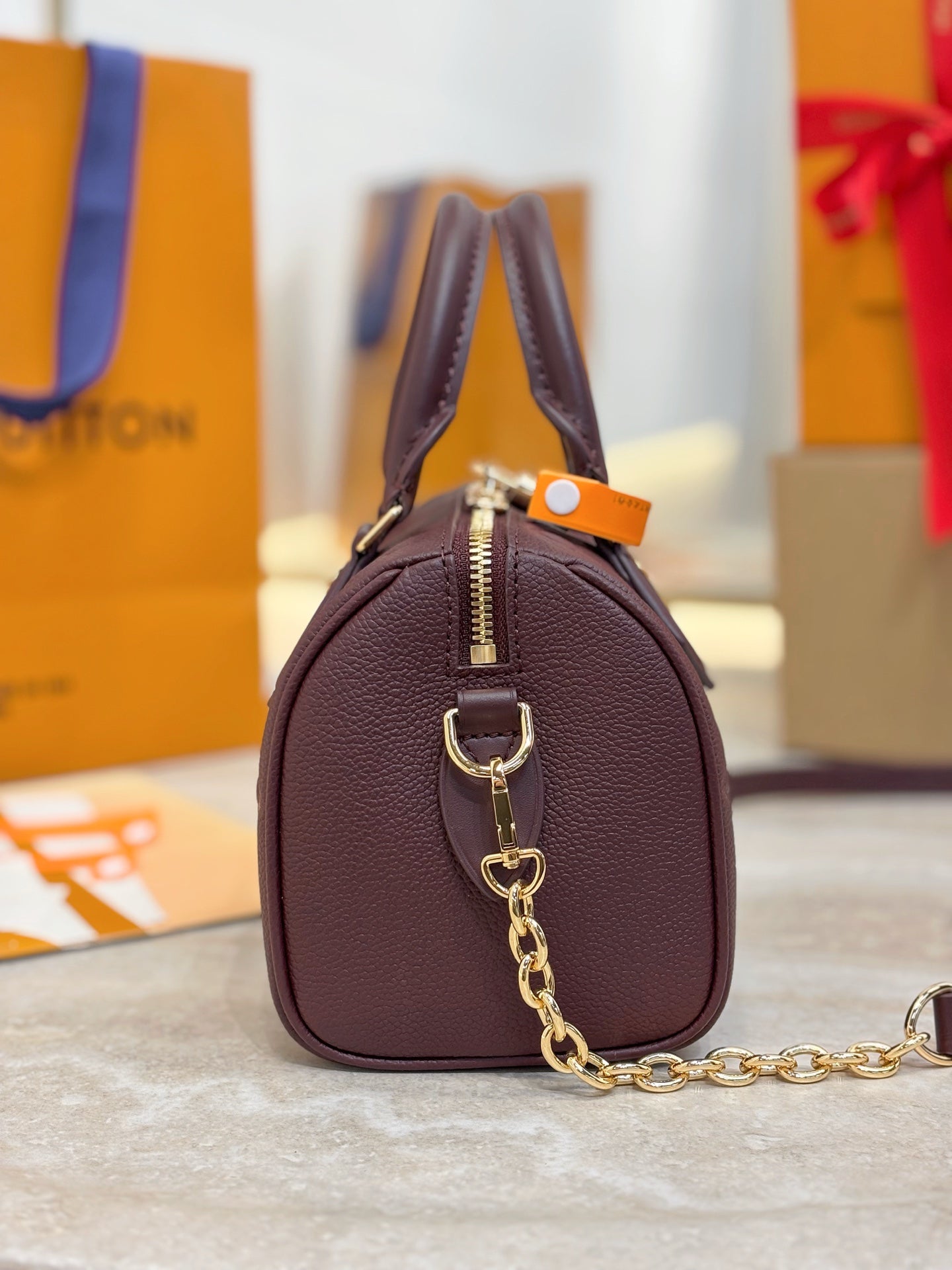 Louis Vuitton maroon leather mini bag with front zipper, handle loop, and chain strap