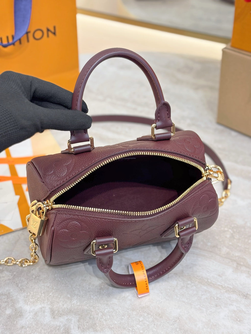 Louis Vuitton maroon leather mini bag open view with gold zipper and chain strap