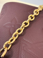 Louis Vuitton maroon leather bag close-up of gold-tone chain strap