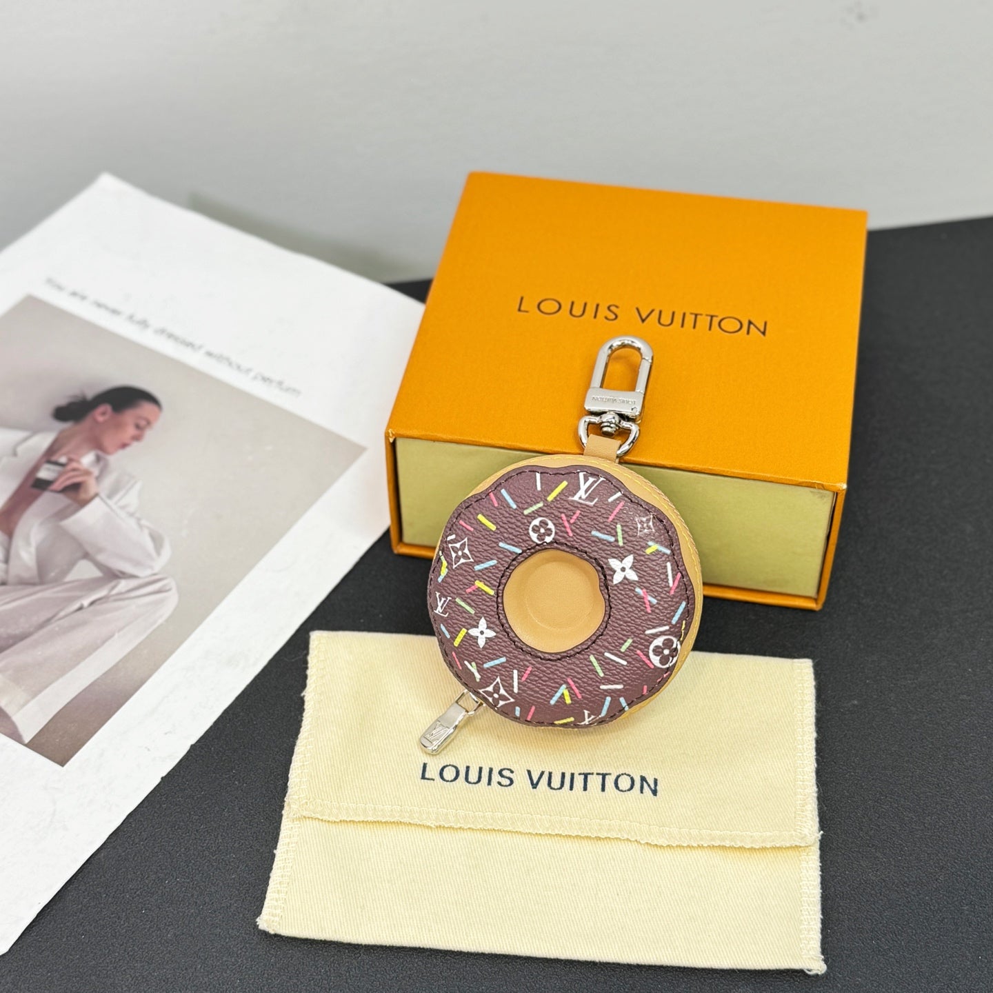 Donut-shaped key pouch with dark canvas, multicolor accents, and metal clasp