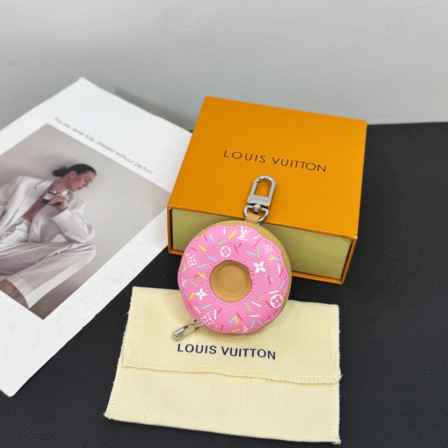 Louis Vuitton donut key pouch keychain with pink monogram pattern on cream dust bag