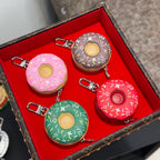 Donut-shaped keychains on red insert in pink, green, brown, and red with metal clips