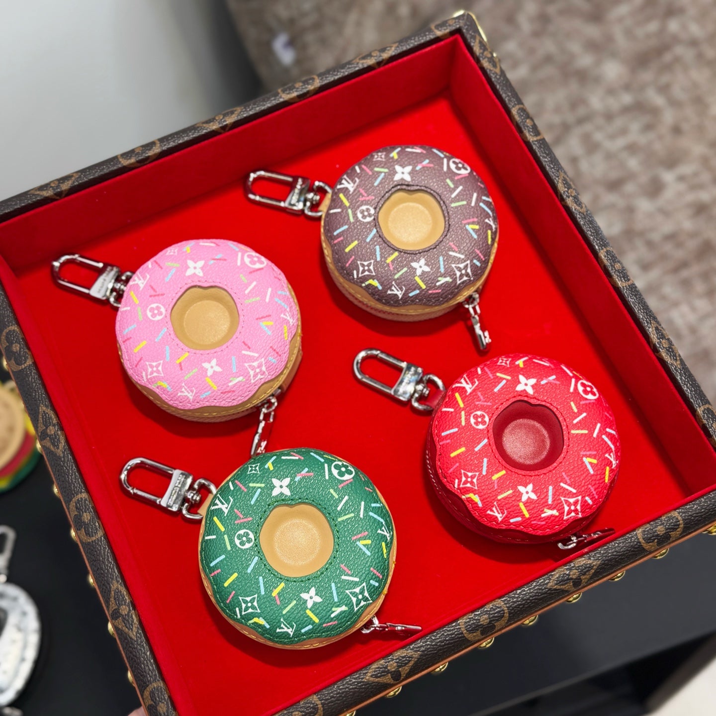 Donut-shaped keychains on red insert in pink, green, brown, and red with metal clips