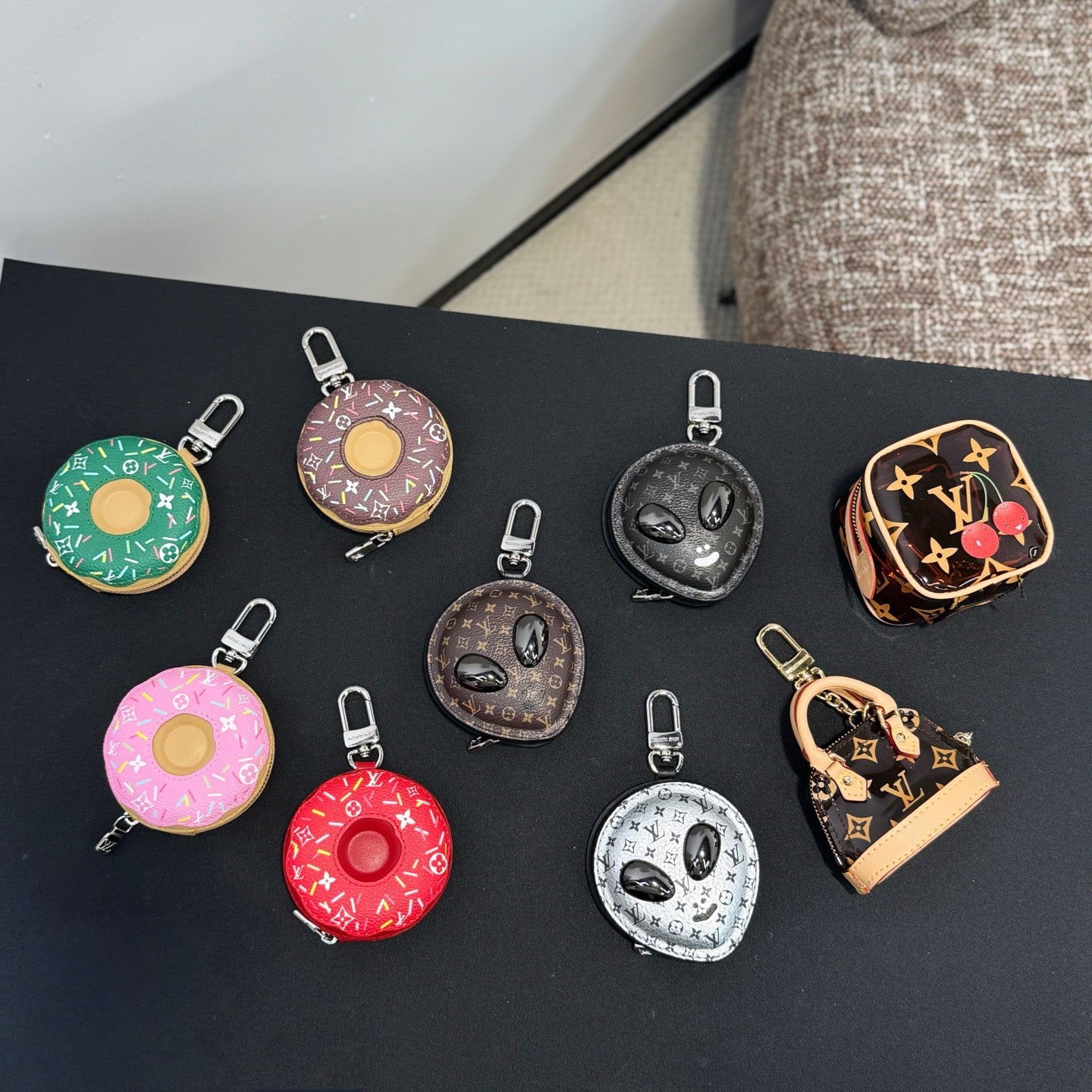 Assorted small keychains in dark tones, including donut and heart shapes, metal clips