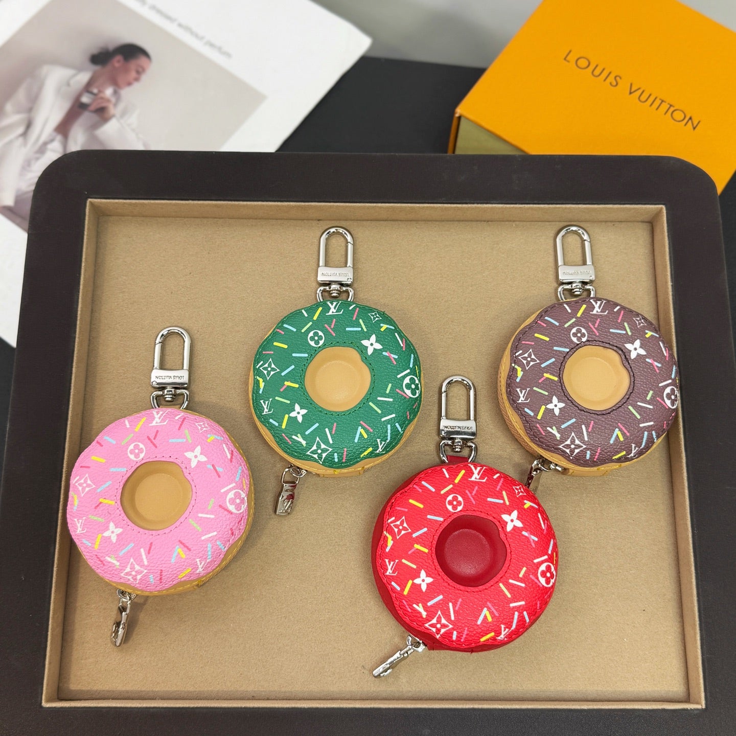 Boxed donut-shaped keychain set in green, purple, pink, and red with metal clips