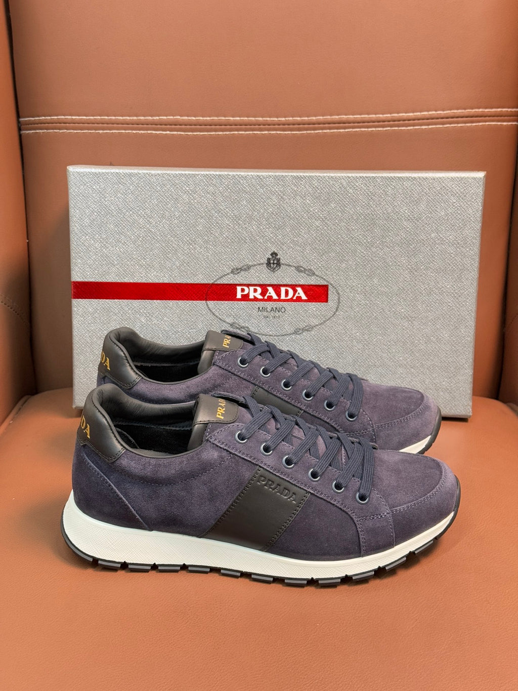 Dark blue suede lace-up sneakers with Prada logo patch and white sole
