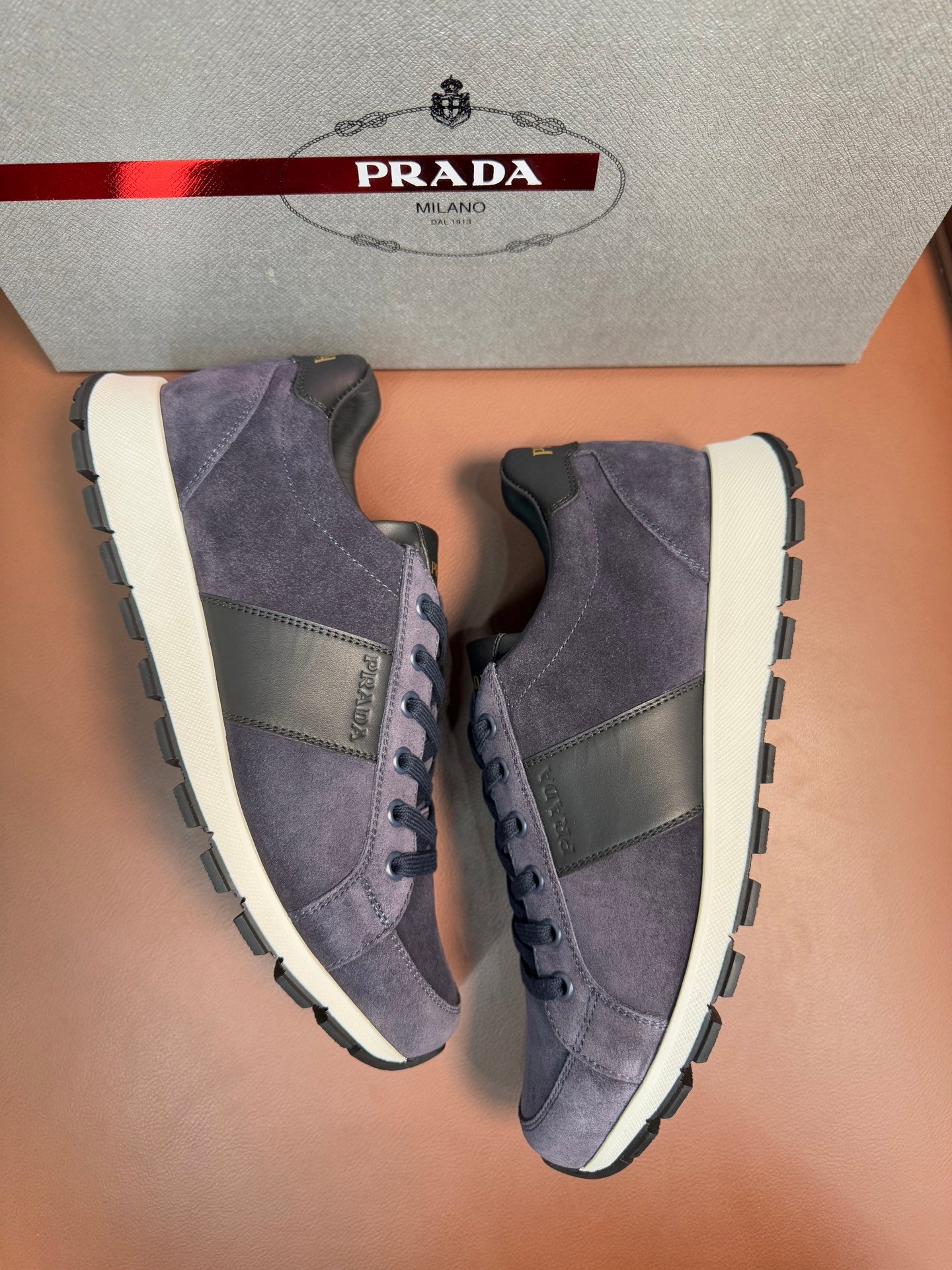 Dark blue suede high-top sneakers with white soles and lace-up front