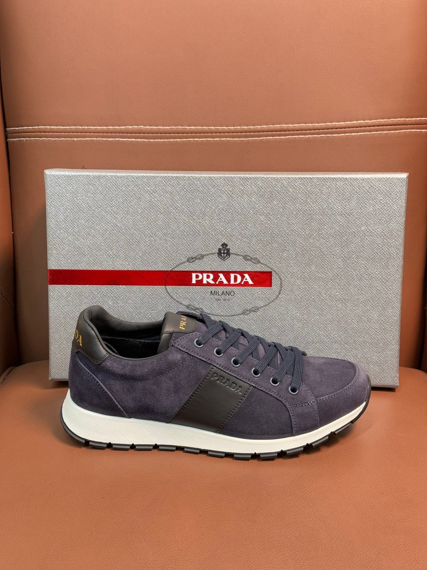 Dark blue suede lace-up sneakers with round logo patch and white sole