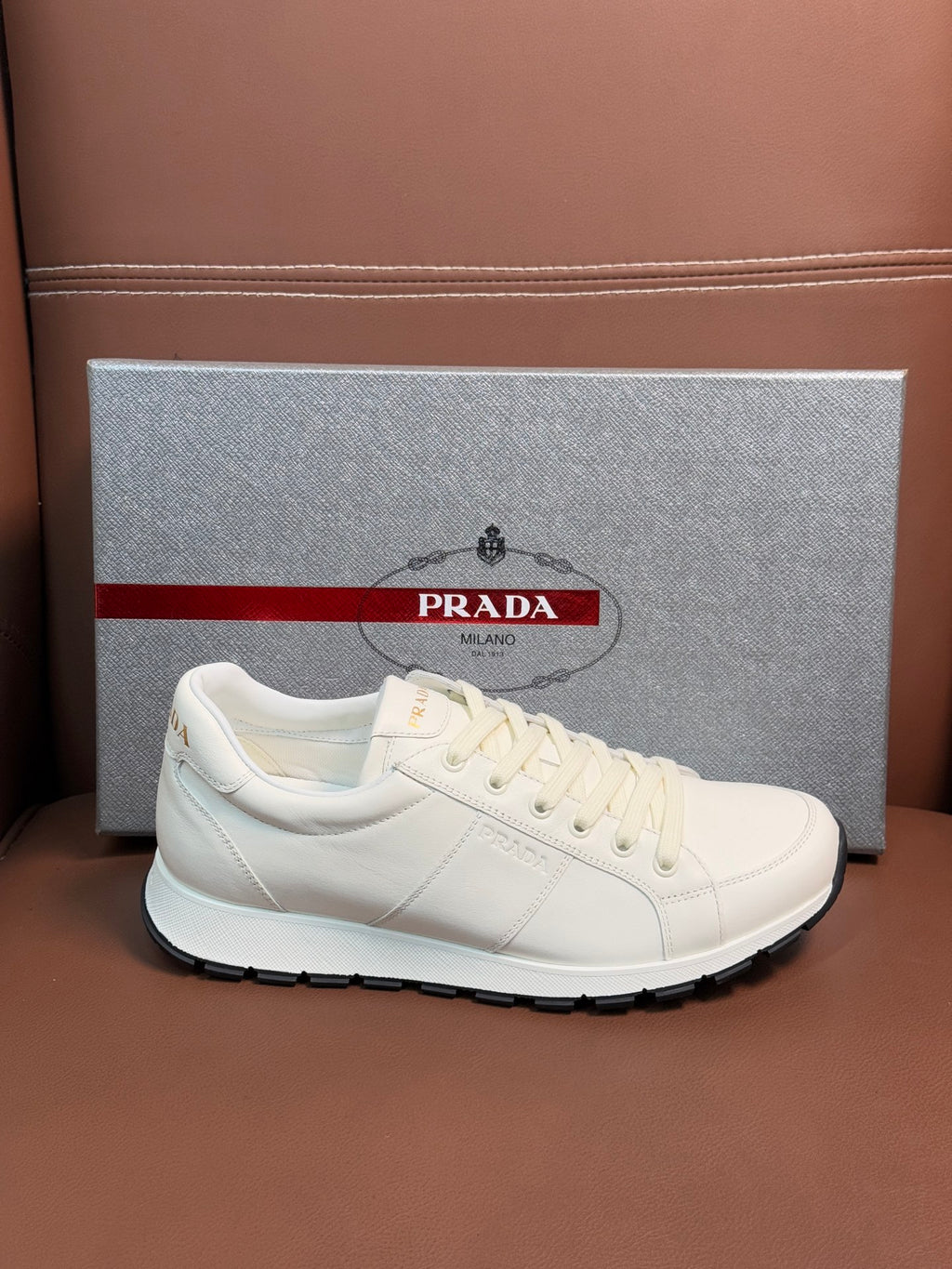 White leather lace-up sneaker with flat rubber sole and subtle side stitching