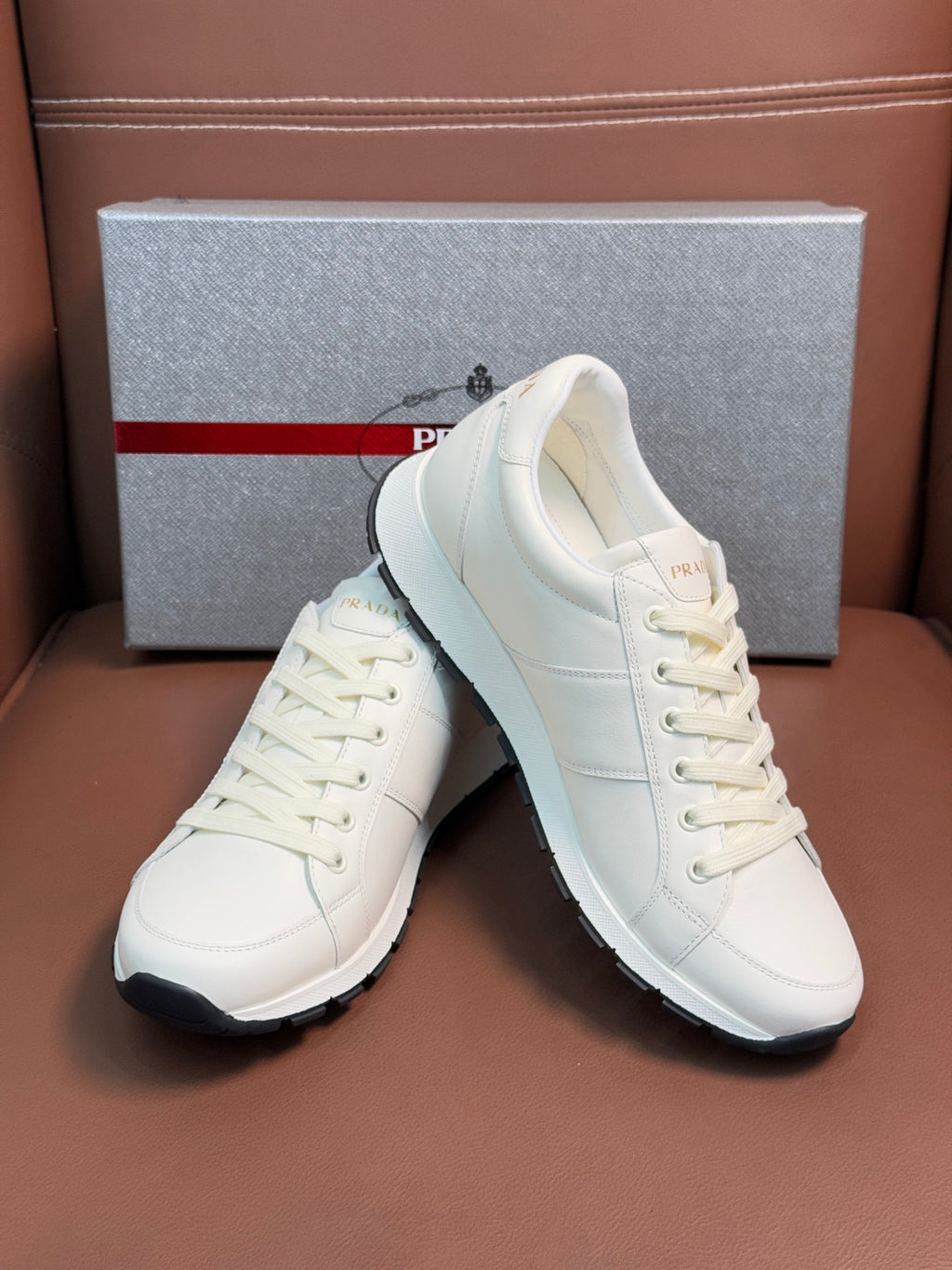 White lace-up sneakers, front view with black rubber heel and side panels