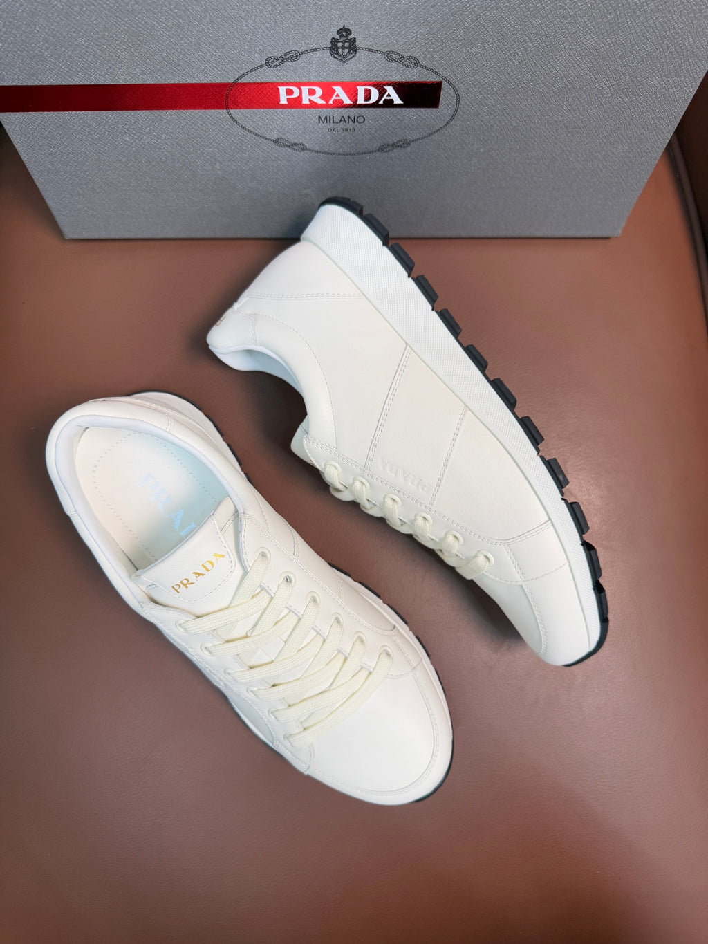 White lace-up sneaker pair with textured rubber sole and stitched side panels