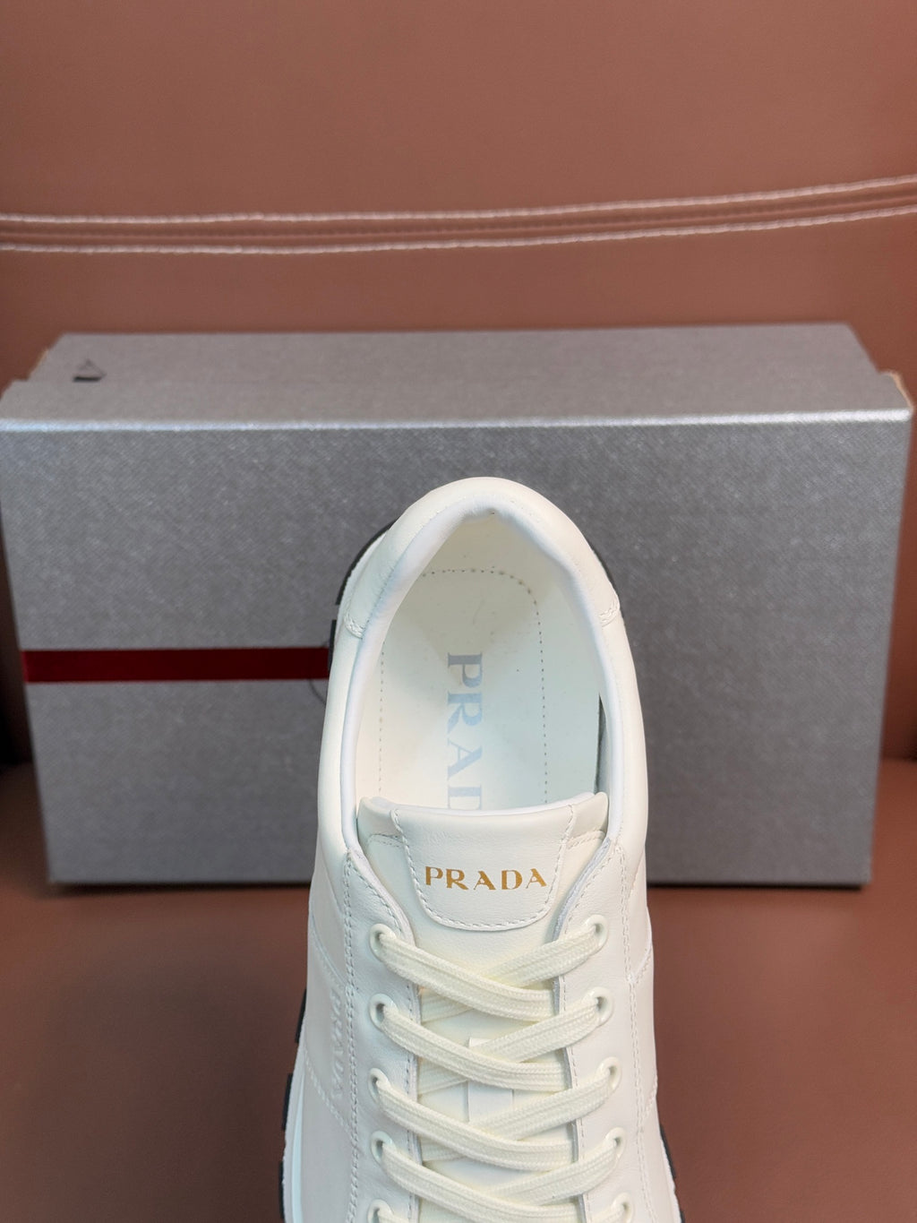 White lace-up sneaker with Prada logo on tongue and lightly padded collar