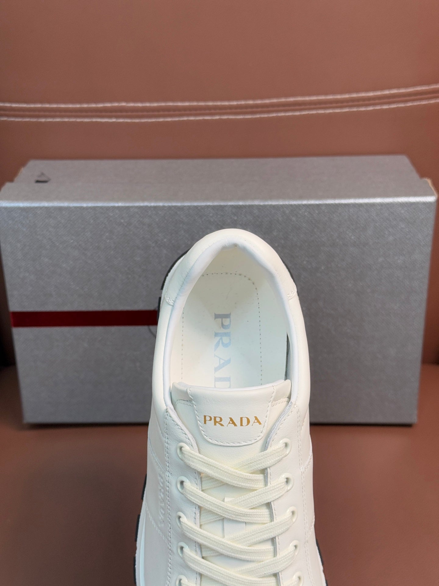White lace-up sneaker with Prada logo on tongue and lightly padded collar