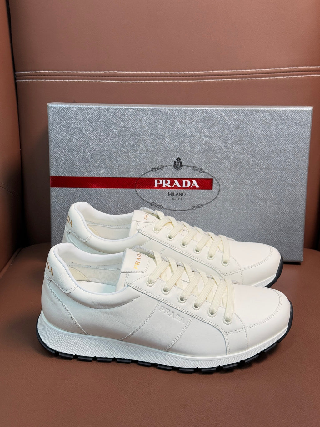 White leather lace-up sneaker with Prada branding and black rubber outsole
