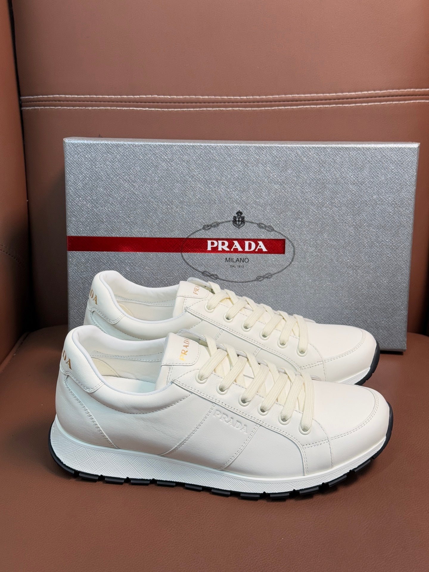 White leather lace-up sneaker with Prada branding and black rubber outsole