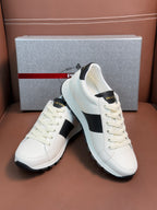 White Prada unisex sneakers with black side panels and white laces, angled view