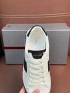 White Prada unisex sneaker close-up: lace-up front with black heel collar