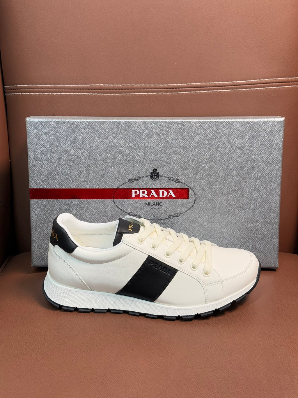 White Prada unisex low-top sneakers with black side stripe and white laces