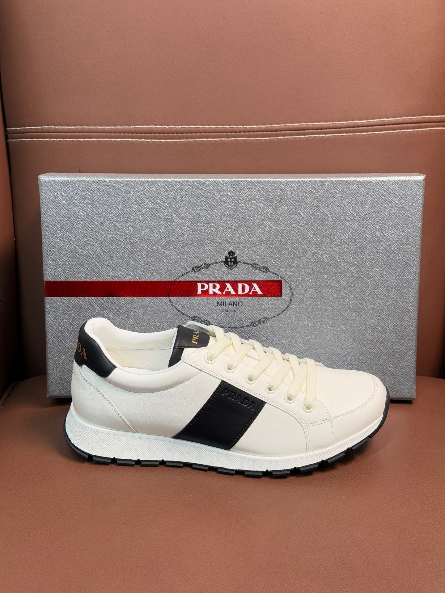 White Prada unisex low-top sneakers with black side stripe and white laces