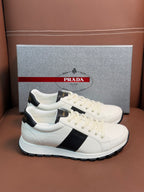 White Prada unisex low-top sneakers with black stripe detail and lace-up front