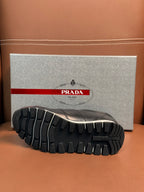 Prada unisex sneaker outsole view with deep tread pattern and dark rubber grip