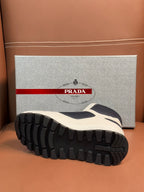 Sole view of lace-up sneakers with deep tread and white/dark navy upper