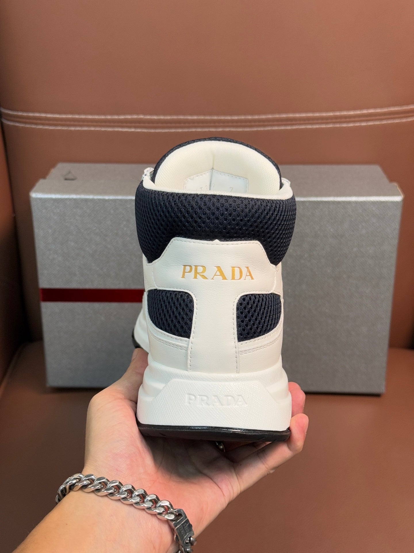 Back of lace-up sneakers with dark navy heel collar and PRADA label