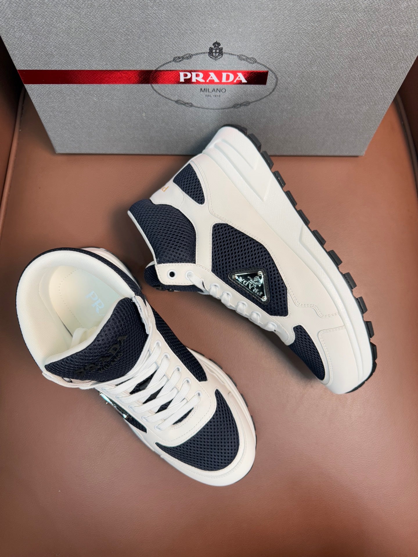 Pair of lace-up sneakers with white uppers and dark navy side panels