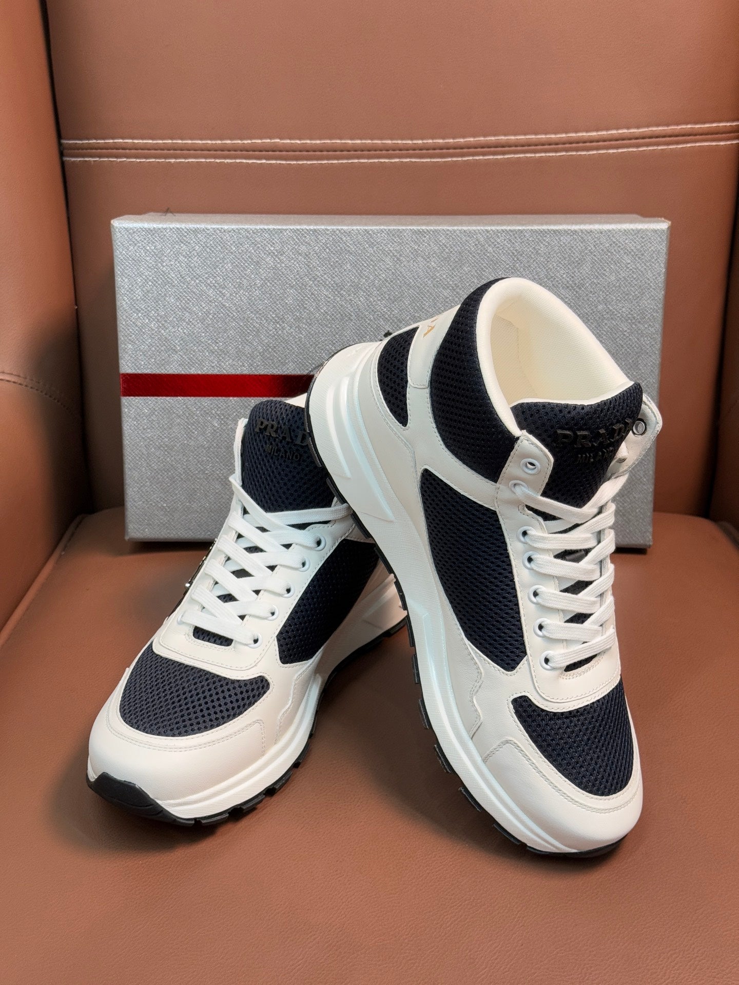 Lace-up sneakers in white with dark navy accents and thick cushioned sole