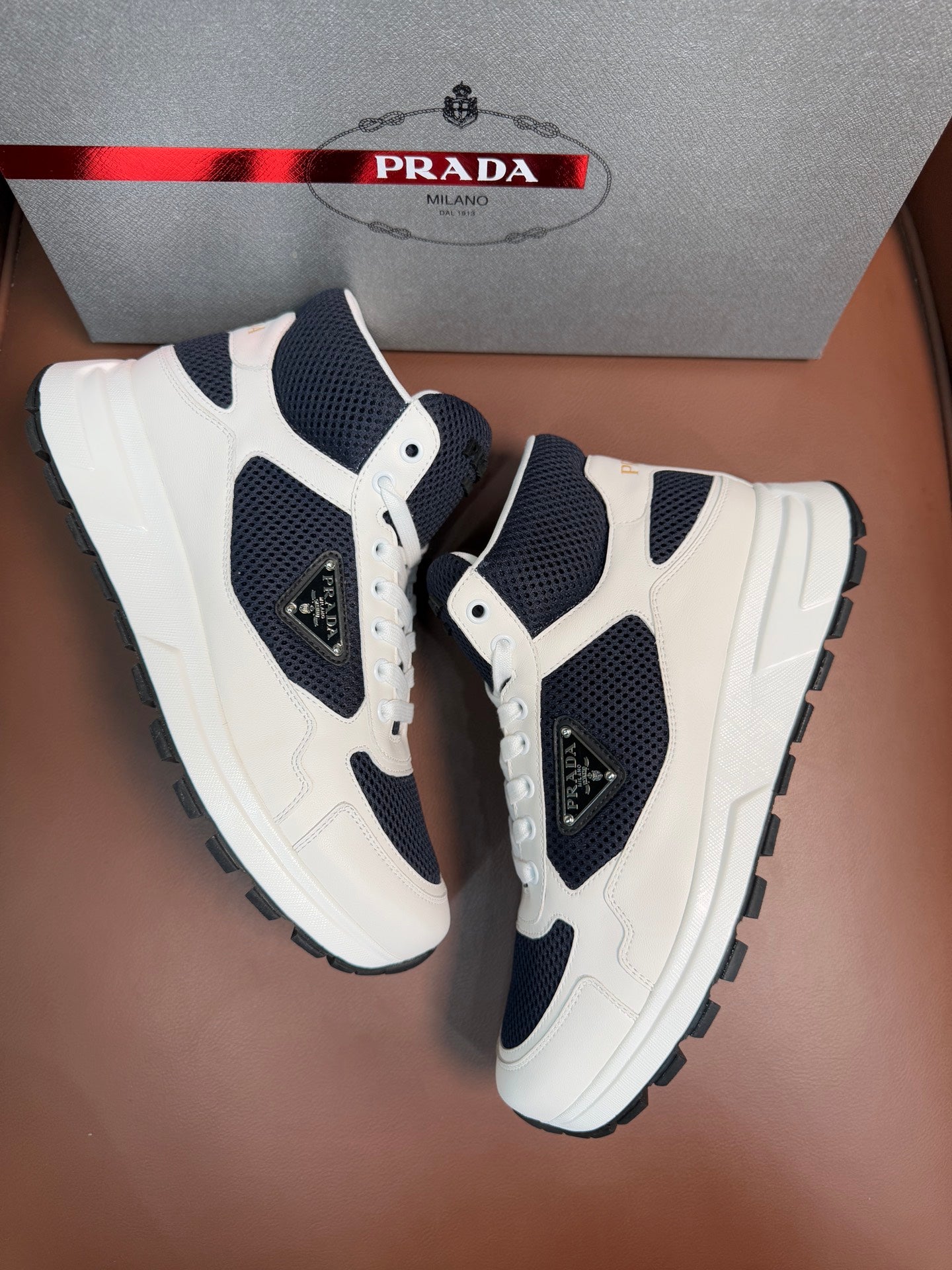 Low-top lace-up sneakers in white leather with dark navy inserts and logo detail