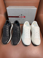 Prada unisex sneaker pair: dark charcoal and white lace-up low-tops