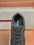 Prada unisex dark charcoal sneaker, close-up front with mesh vamp and laces