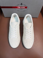 White leather low-top sneakers with white laces and cushioned tongue