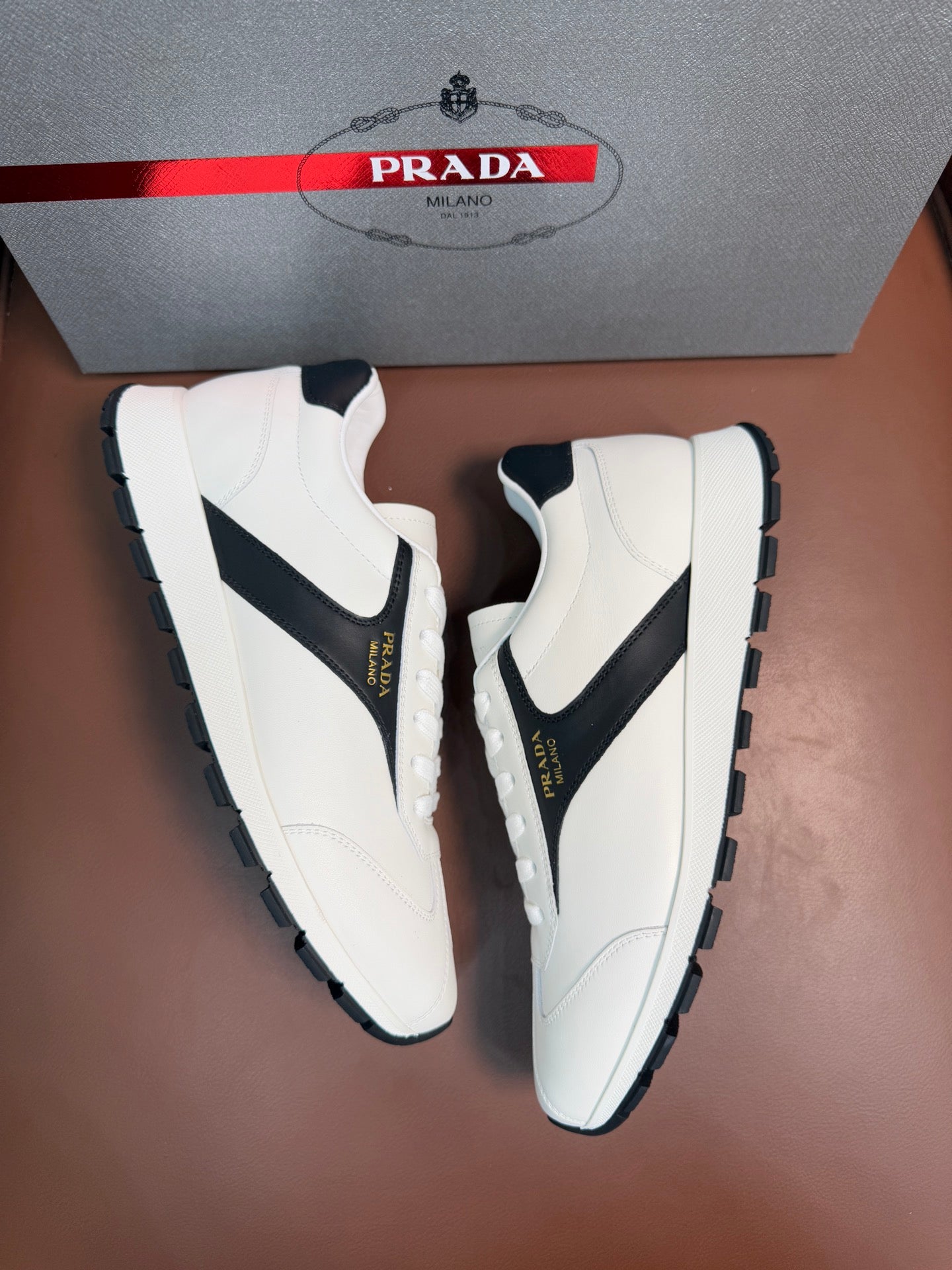 White unisex sneakers with black quarter panels, lace-up closure