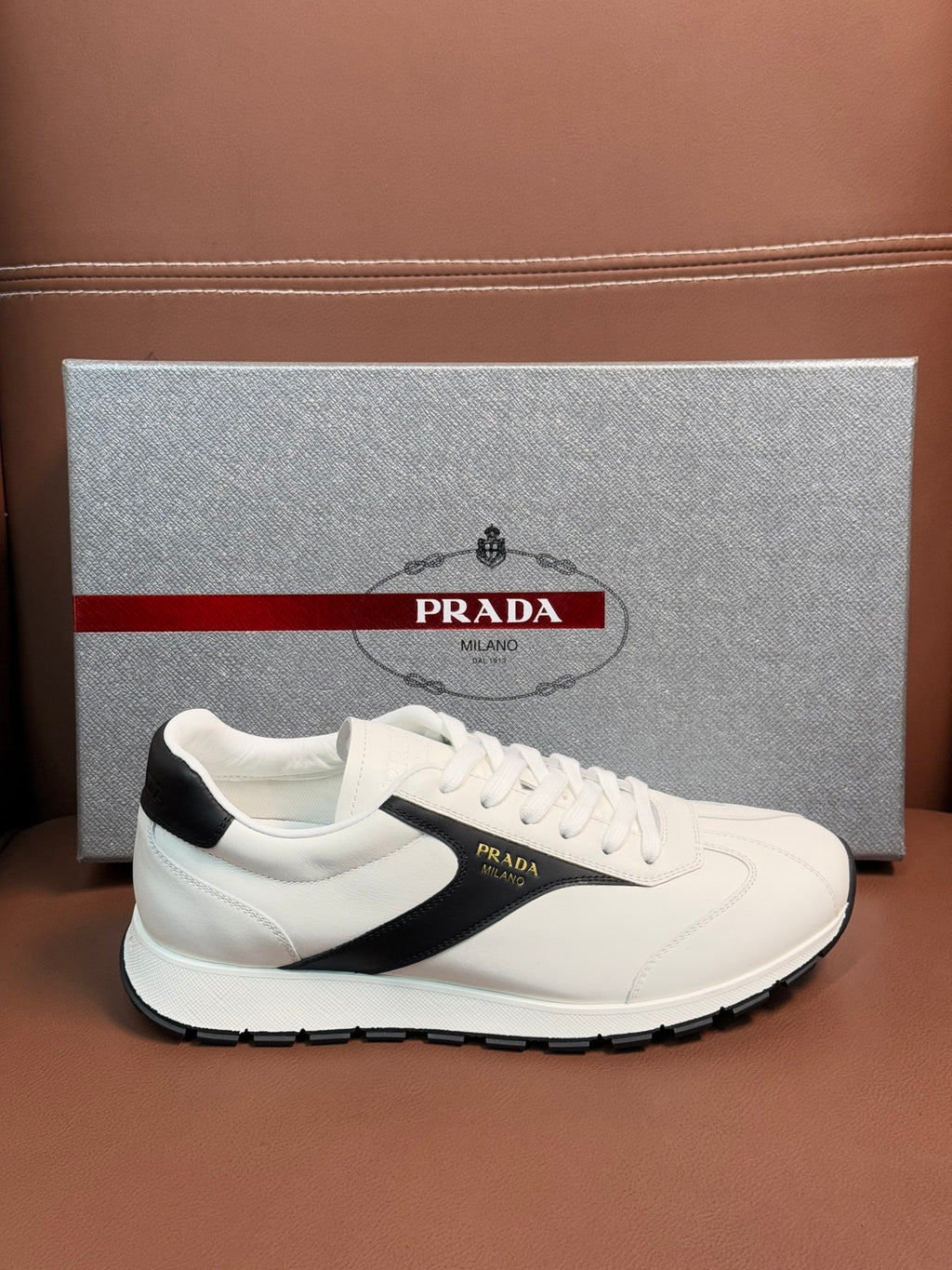 White unisex sneakers with black side stripe and lace-up eyelets