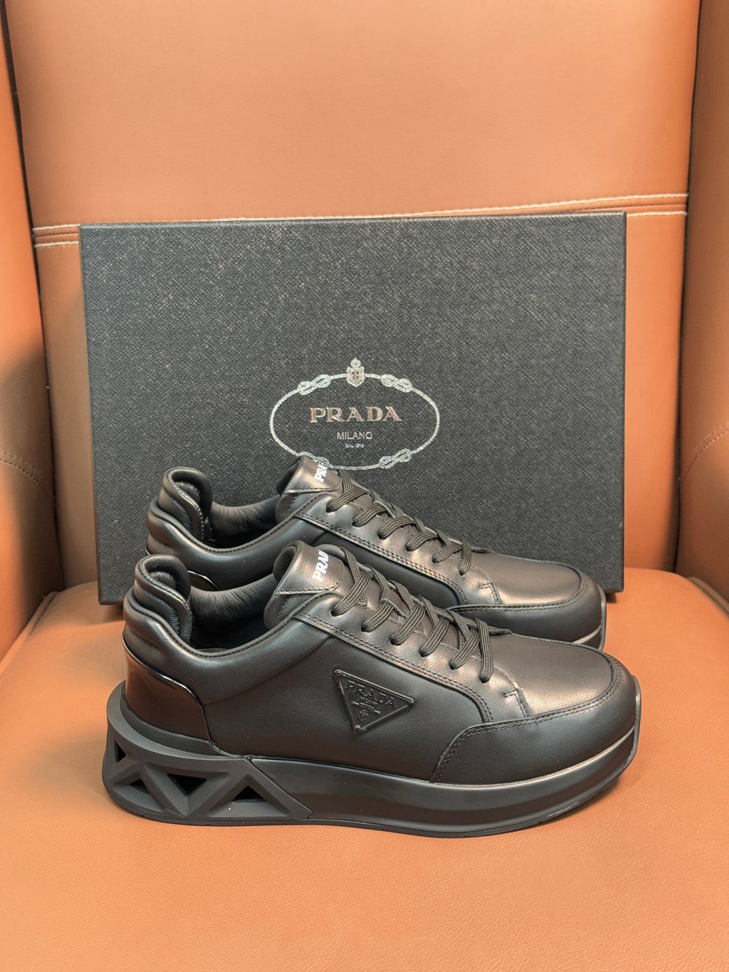 Prada dark lace-up sneakers with sculpted sole and triangular logo patch