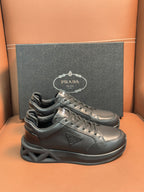 Prada dark lace-up sneakers with sculpted sole and triangular logo patch