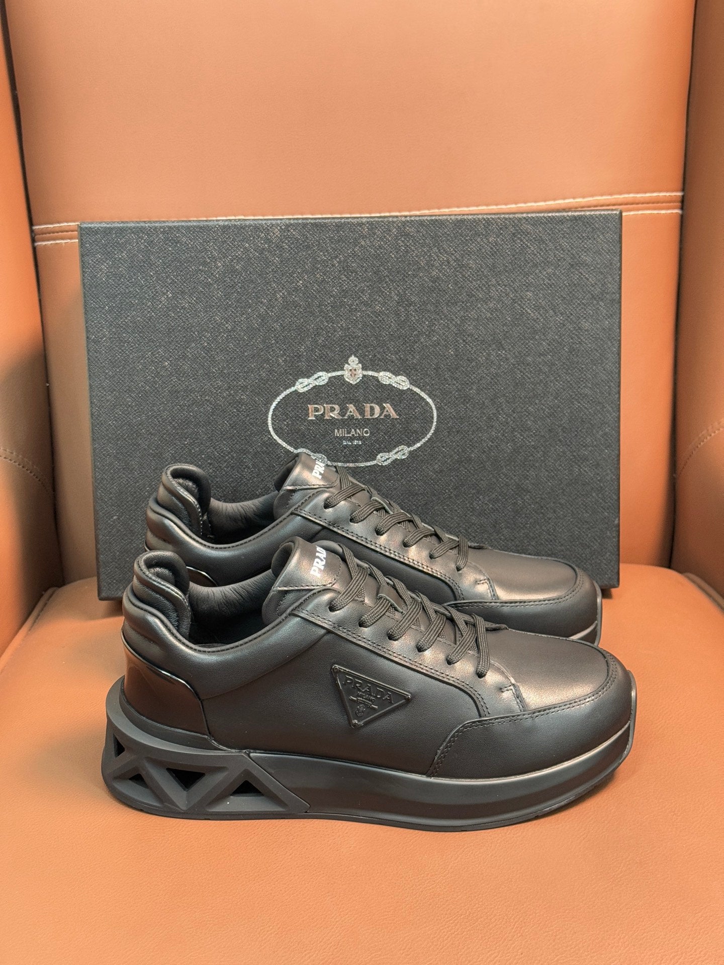 Prada dark lace-up sneakers with sculpted sole and triangular logo patch