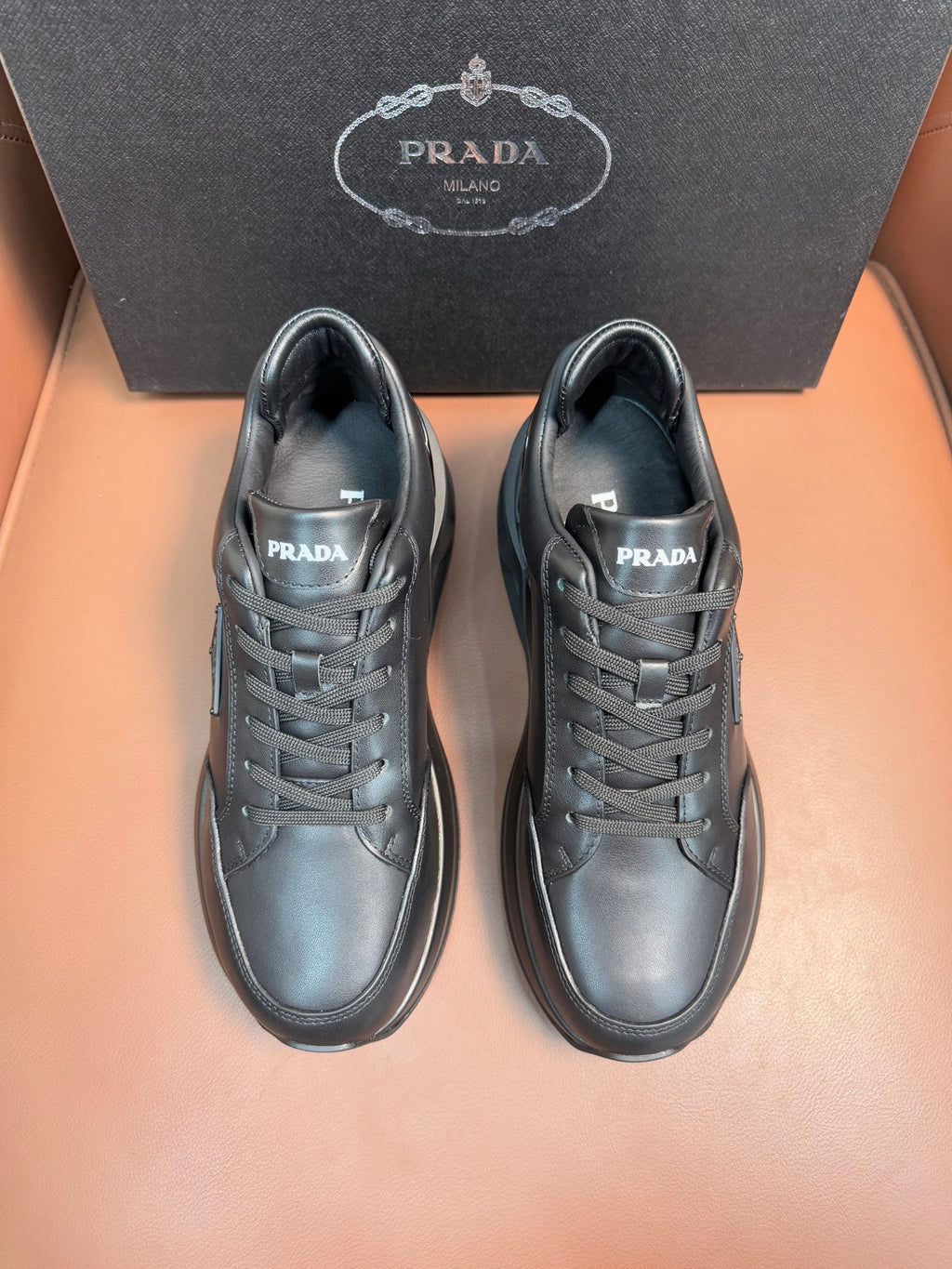 Prada dark sneakers, lace-up front and logo on tongue