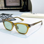 Chrome glasses with gold frame and green-tinted lenses, front view