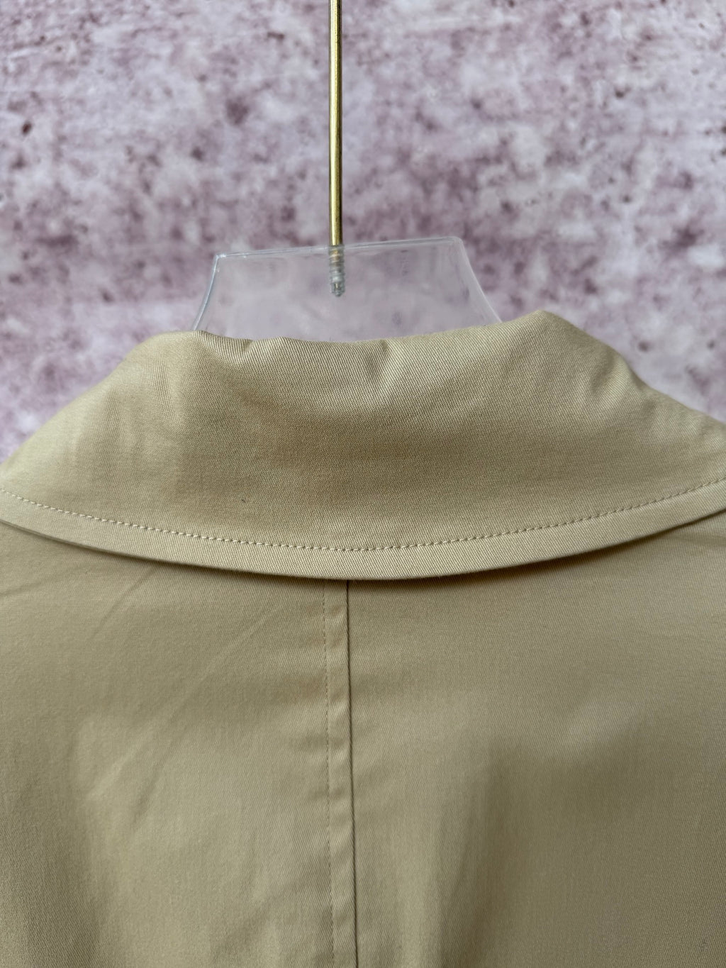 Tan coat back yoke seam and standing collar edge.