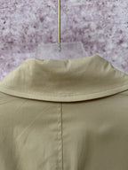 Tan coat back yoke seam and standing collar edge.