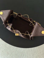 Chanel bag interior view with gold chain strap and dark plum leather top edge