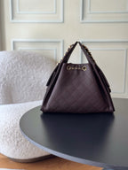 Chanel bag in dark plum quilted leather with gold chain strap and front logo clasp