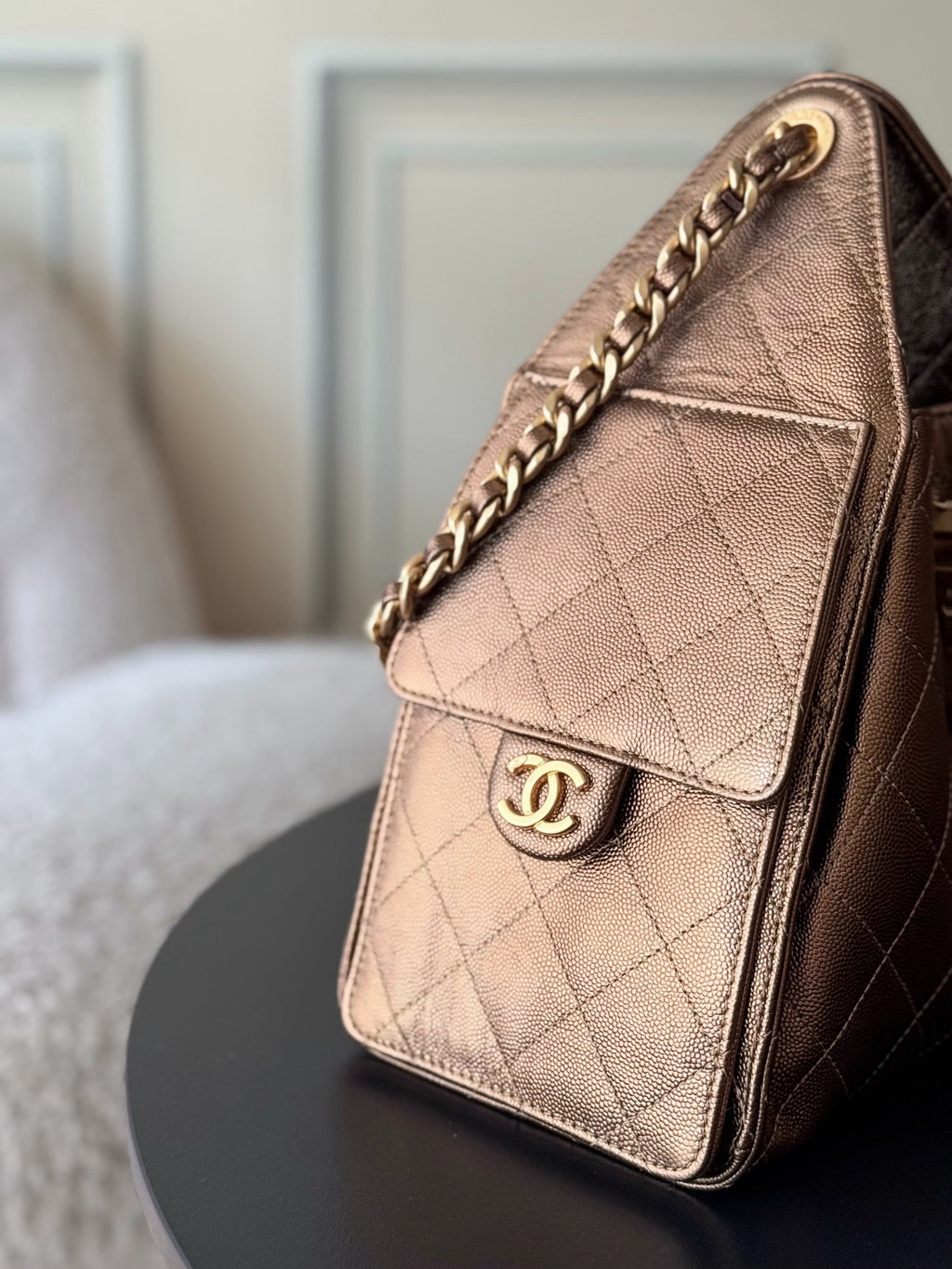Brown quilted shoulder bag with flap, gold-tone Chanel logo, and chain trim