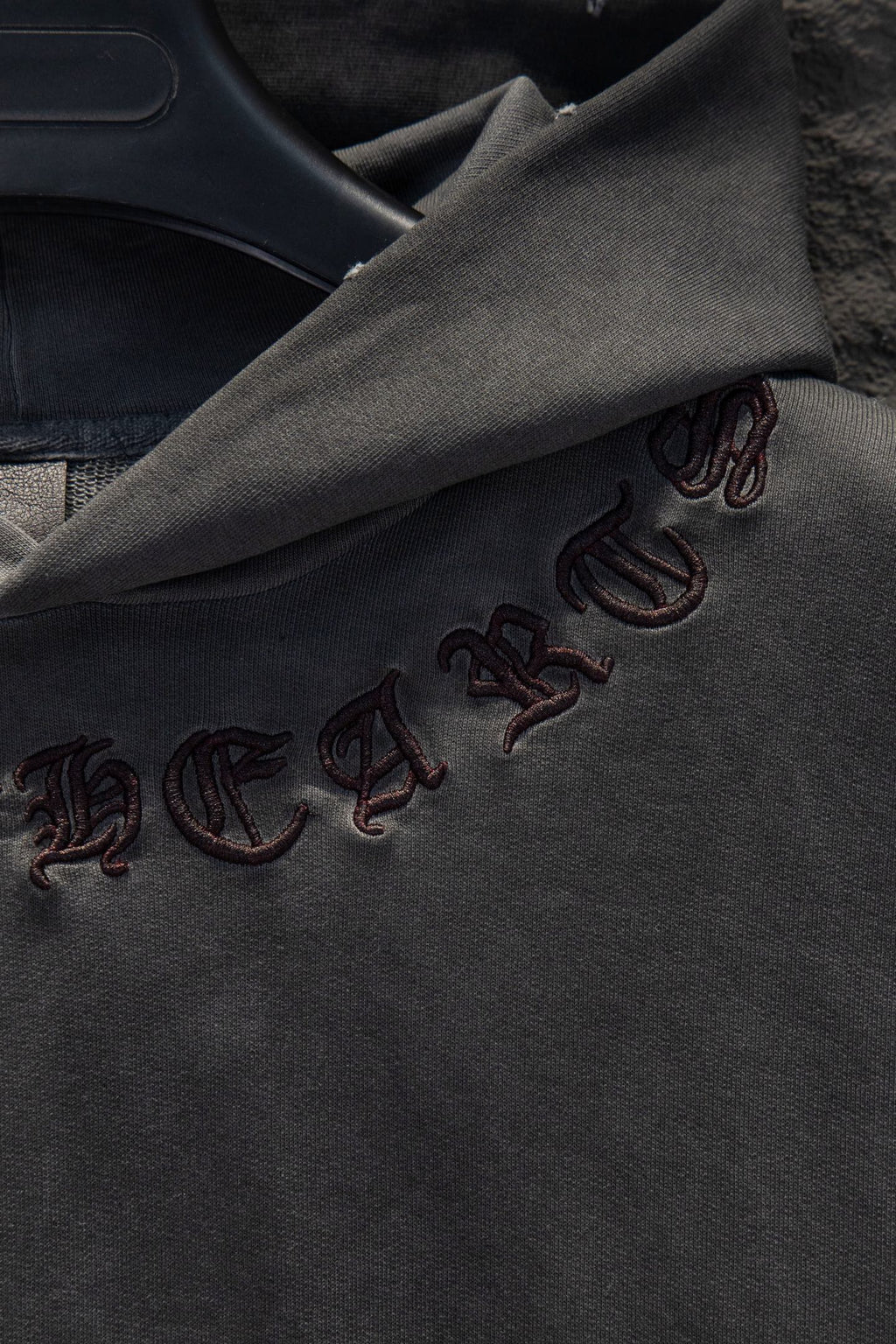 Embroidered symbols along dark gray hoodie sleeve