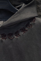 Embroidered symbols along dark gray hoodie sleeve