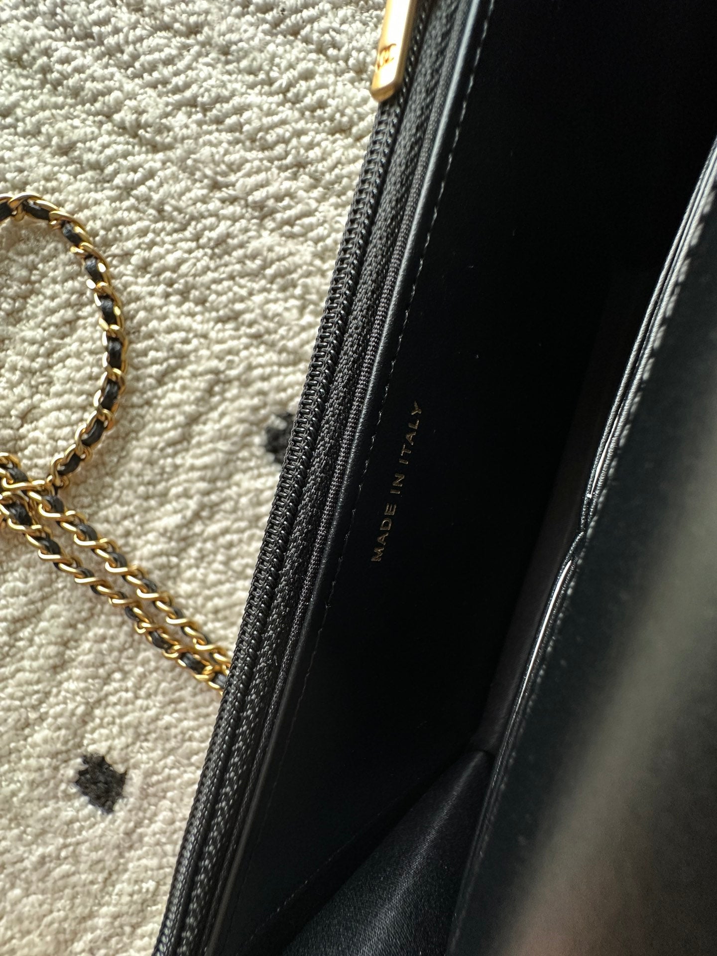 Black interior lining with zipper and gold-tone chain hardware