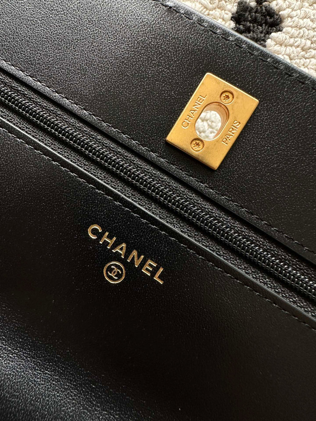Black leather bag lining label with gold-tone Chanel and zipper track